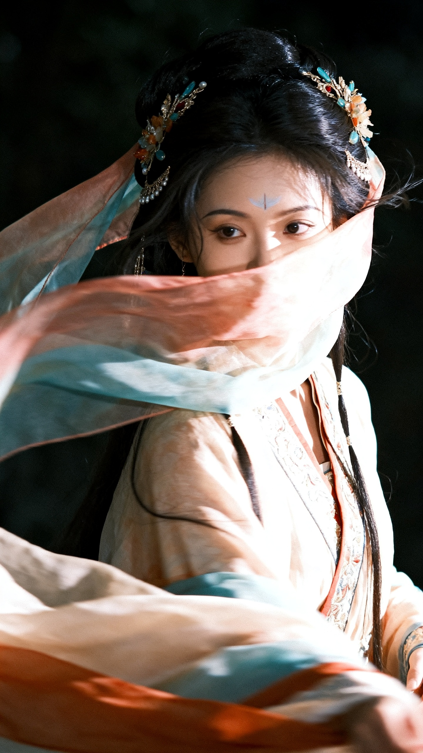 胶片摄影，对焦模糊，高曝，过曝，暗调，伦勃朗光，强烈明暗对比，高反差，绝世美女，两鬓装点着发饰，华丽发饰，松散半盘发垂髻，淡彩配色，头纱拂面，大风吹过，柔软布料衣物，魏晋风华丽交领大袖衫，双鬓有两缕细发，披肩长发，额间… - AI提示词参考图，来自西西提示词