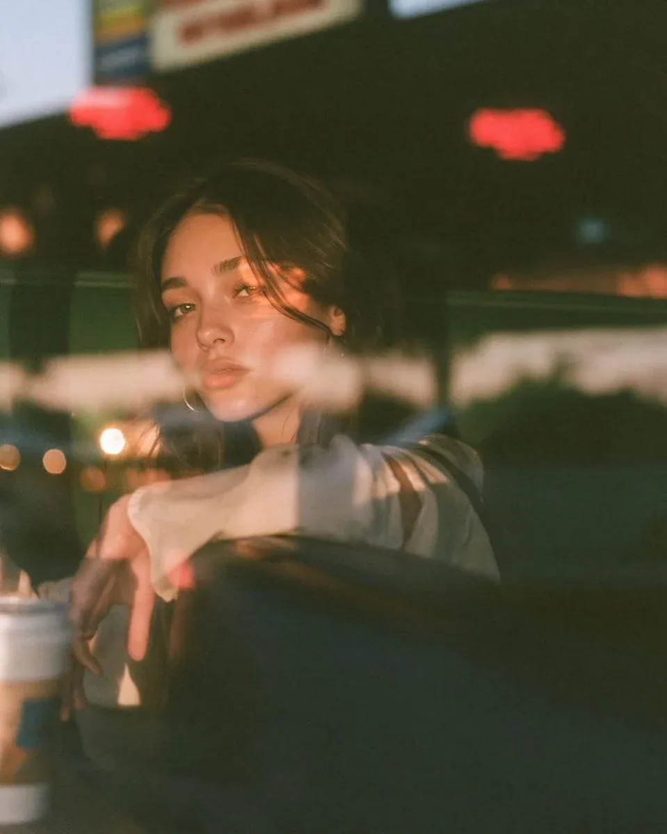 Ultra-cinematic lifestyle portrait photographed through a café window at blue hour, beautiful young woman sea… - AI提示词参考图，来自西西提示词