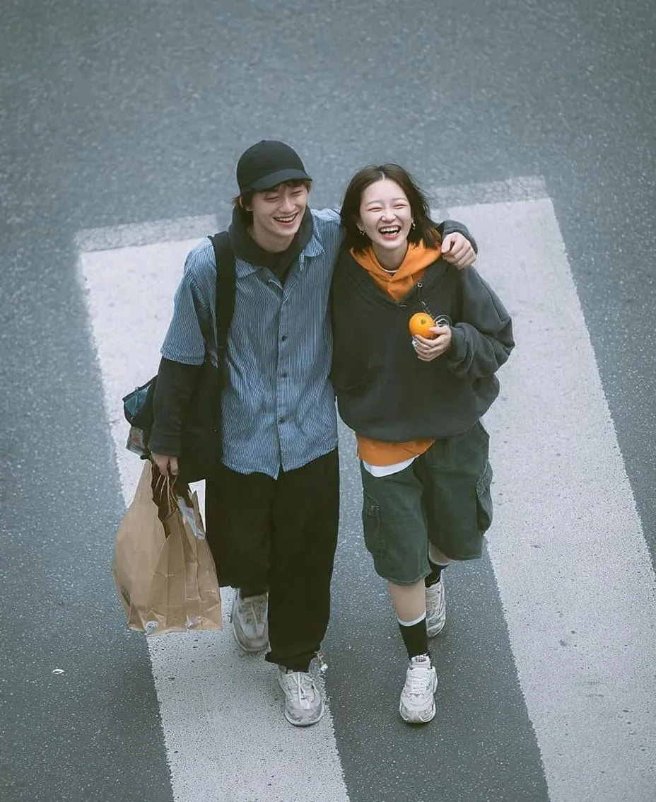 A cinematic overhead street photo of a young couple walking on a zebra crossing, candid and natural interacti… - AI提示词参考图，来自西西提示词
