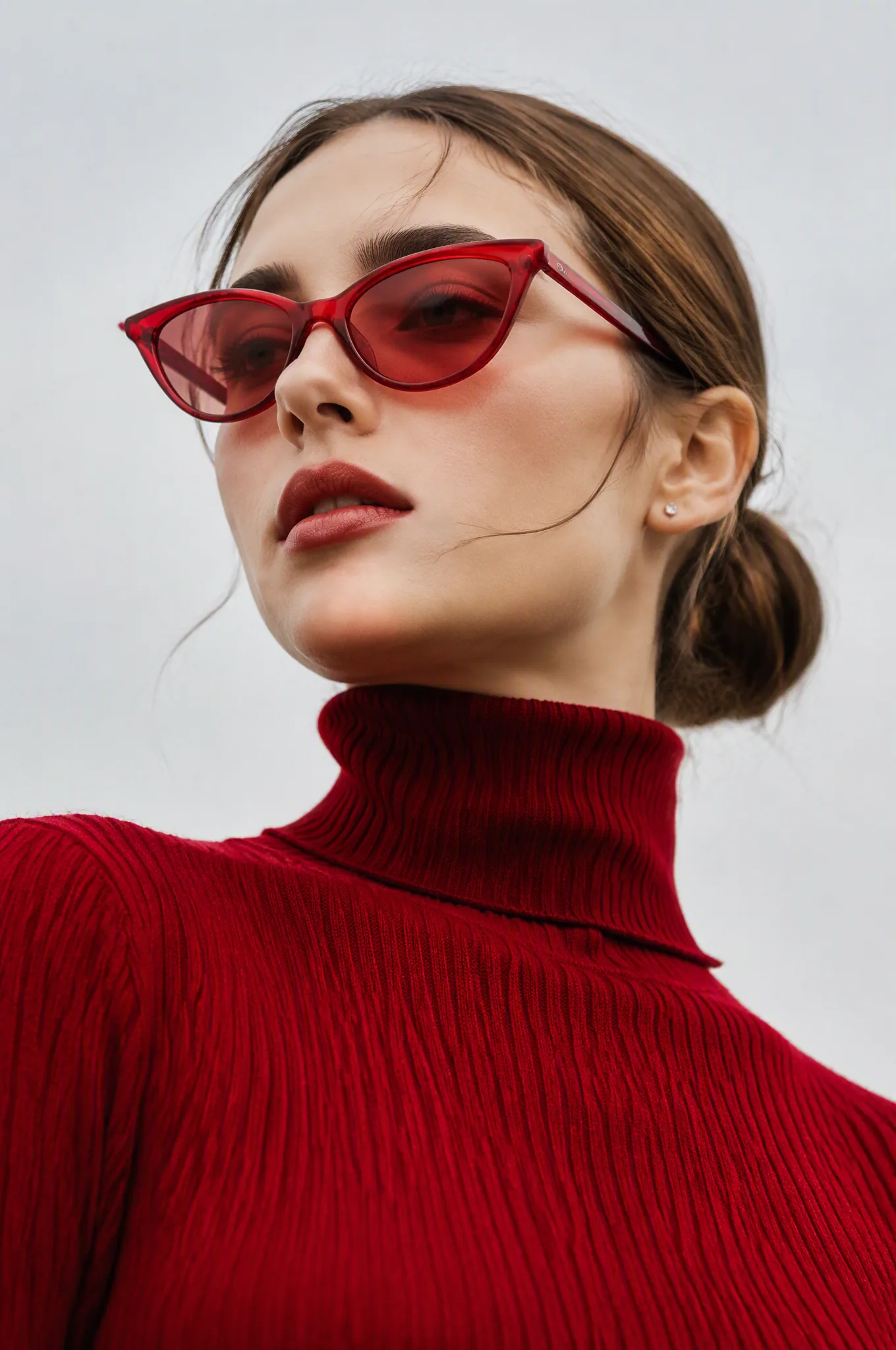 A low-angle editorial fashion portrait of a young woman with porcelain skin, wearing a vibrant crimson red ri… - AI提示词参考图，来自西西提示词