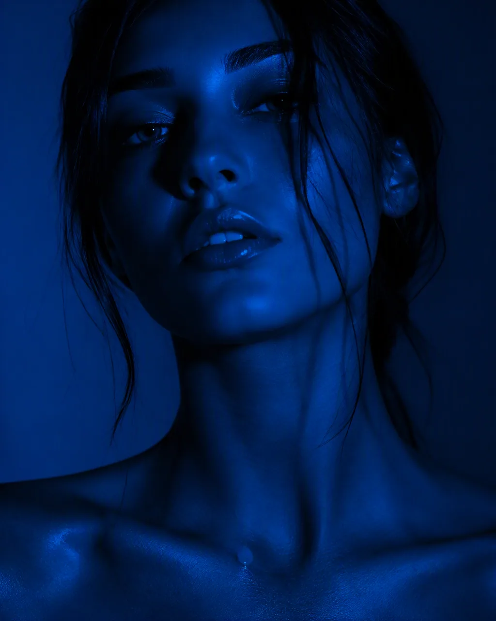 Create a hyper-realistic cinematic beauty portrait of a woman bathed entirely in deep cobalt-blue light, high… - AI提示词参考图，来自西西提示词