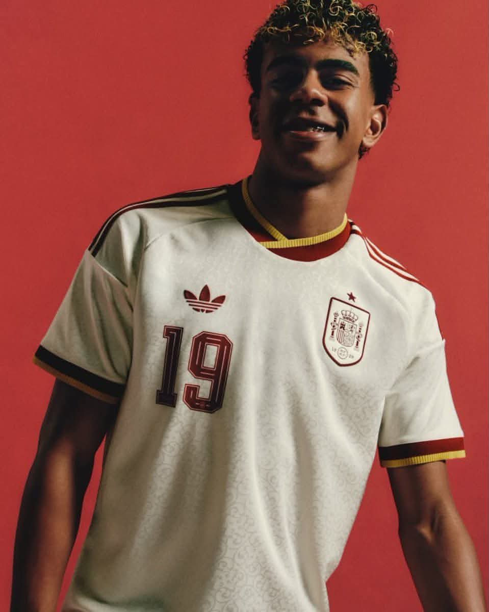 A stylish young football player wearinga retro-inspired white national teamjersey with deep red and gold acce… - AI提示词参考图，来自西西提示词