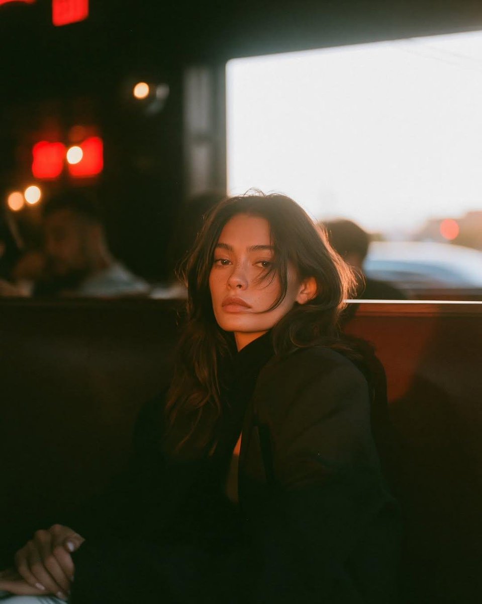 A cinematic café portrait of a beautiful young woman sitting alone in a {argument name="setting" default="coz… - AI提示词参考图，来自西西提示词