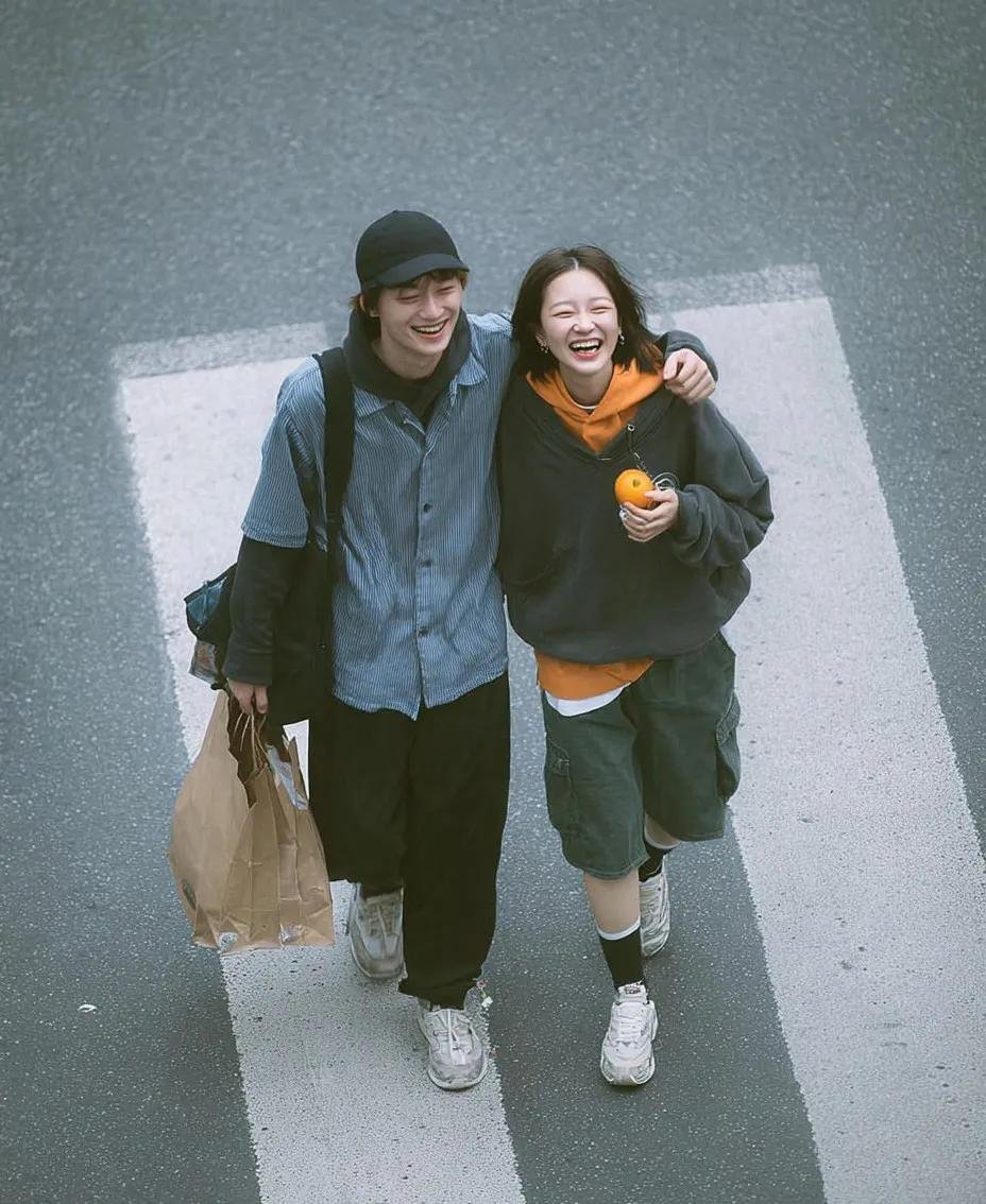 A cinematic overhead street photo of a young couple walking on a zebra crossing, candid and natural interacti… - AI提示词参考图，来自西西提示词