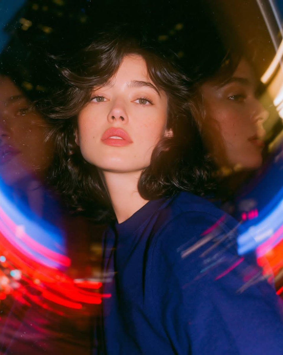 Photorealistic experimental cinematic portrait inside a large rotating glass entrance at night. One naturally… - AI提示词参考图，来自西西提示词