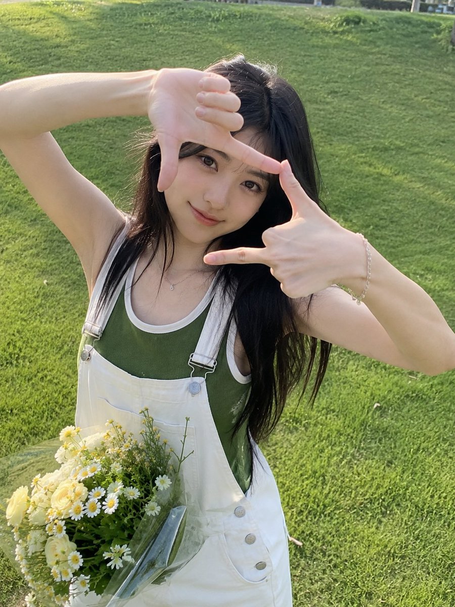 A charming outdoor portrait of a young woman standing on a lush green lawn, looking directly at the camera wh… - AI提示词参考图，来自西西提示词