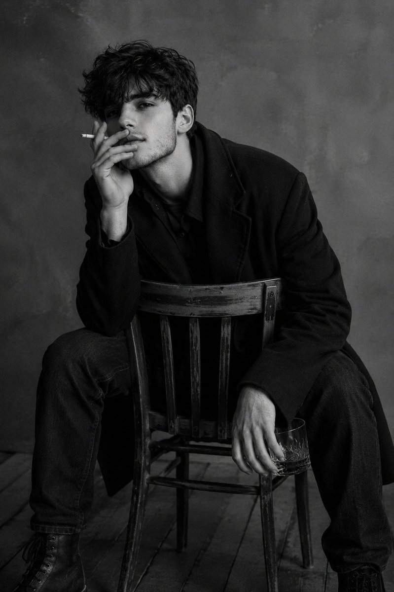 Scene Description and Camera Angle An intimate indoor portrait of a man sitting on a wooden chair turned back… - AI prompt reference from CC Prompt Galaxy