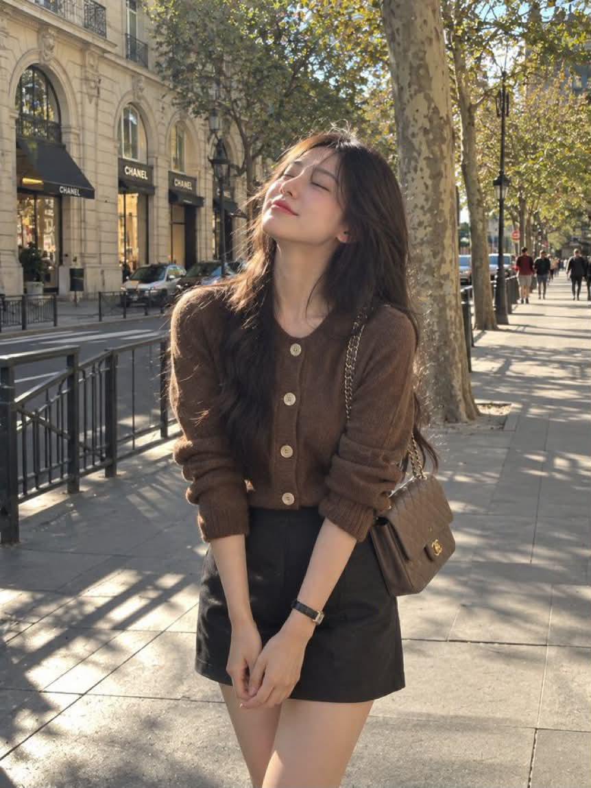 A photorealistic candid street-style portrait of a young woman standing outdoors on an elegant city boulevard… - AI提示词参考图，来自西西提示词